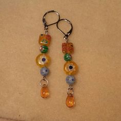 a pair of dangling earrings with glass beads