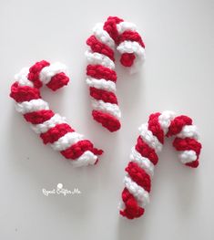 two red and white candy canes sitting on top of a table next to each other