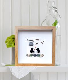 a white shelf with a glass vase and some rocks