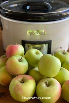 a pile of green apples sitting in front of an instant pot