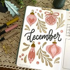 a notebook with the word december written on it next to some pens and other items