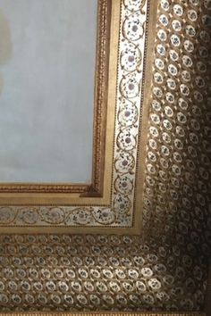 an ornate gold framed painting on the wall