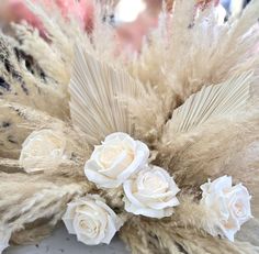 some white flowers and feathers on a table