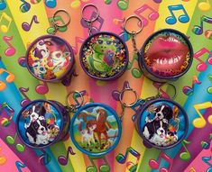 four key chains with pictures of dogs on them and music notes in the back ground