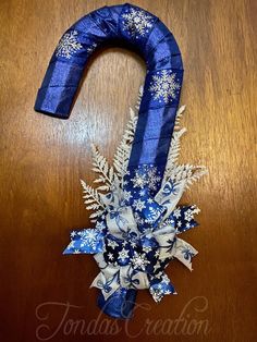 a blue and white wreath with snowflakes on it sitting on top of a wooden table