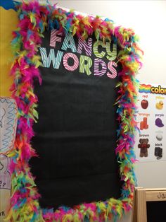 a classroom bulletin board decorated with colorful feathers and writing on it that says fancy words