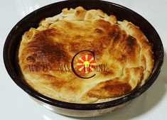 a pie sitting in a pan on top of a white table next to a red and yellow logo