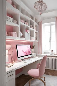 a white desk topped with a computer monitor sitting next to a pink chair in front of a window