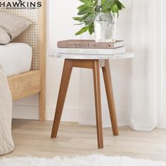 a small table with some books and a potted plant sitting on top of it