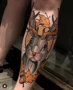 a woman's leg with an orange and black deer tattoo on her calfs