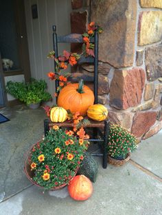 pumpkins and gourds are sitting on the front porch