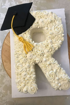 a cake shaped like the letter r with a graduation cap on top and flowers all over it