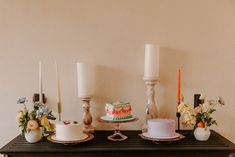 a table topped with cakes and candles on top of it