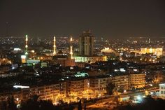 the city is lit up at night with bright lights on it's skyscrapers