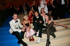 a group of people sitting on the steps at a formal event