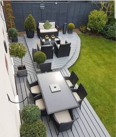 an aerial view of a patio with tables and chairs in the middle of it, surrounded by green grass