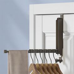 a coat rack with clothes hanging on it next to a door and towel racks in front of the door