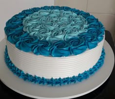 a blue and white cake with ruffles on the top sitting on a table