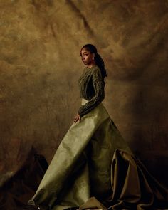 a woman in a long green dress posing for a photo