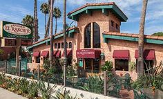 an outside view of a restaurant with palm trees