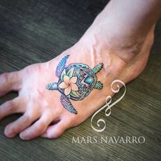 a person's foot with a tattoo on it that has a turtle and flower