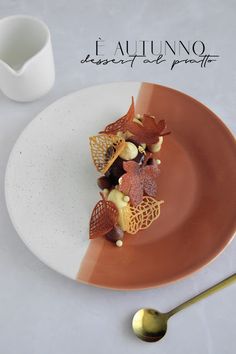 a white plate topped with food next to a fork and cup on top of a table