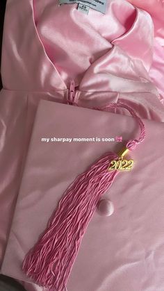 a pink graduation gown with a tassel hanging from it's neck and the words, my happy moment is soon written in gold