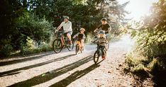 a group of people riding bikes down a dirt road