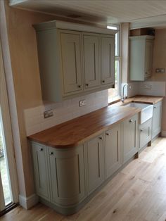 an empty kitchen with wooden floors and cabinets