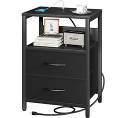 a black night stand with two drawers and a cup on top of the table next to it