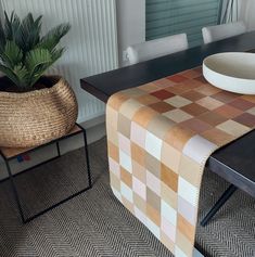 a table with a bowl on it and a plant in the corner next to it