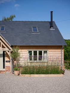 a house with a black roof and white windows