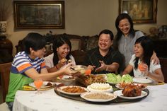 a group of people sitting around a table eating food