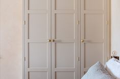 a bedroom with white closets and pillows on the bed