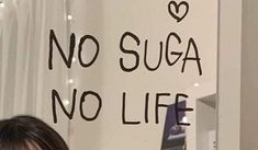 a woman looking at her cell phone in front of a sign that says no sugar, no life