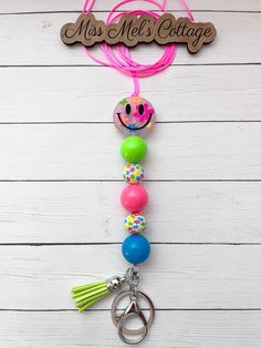 This listing is for one fun Neon Smiley Face Lanyard. Made with a lobster clasp for badges, keyring, beautiful mixed beads - smile face is double sided silicone, chunky acrylic beads, silver flower charm (no shown), tassel, and comfortable, strong cord.   Breakaway clasp will be included for you to add on at your desired length - very easy to do. I do not put the clasp on - this is so you can put it on the cord at the desired length you need. Instructions will be included.)  Cord length comes at Playful Multicolor Craft Supplies For End Of School Year, Trendy Multicolor Lanyards For Gifts, Trendy Multicolor Lanyards As Gifts, Multicolor Fun Craft Supplies For Teacher Appreciation, Fun Multicolor Craft Supplies For Teacher Appreciation, Adjustable Multicolor Badge Reel For Gifts, Adjustable Multicolor Badge Reel For Gift, Adjustable Fun Badge Holders For Gifts, Multicolor Beaded Badge Reel As Gift