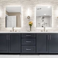 a large bathroom with double sinks and two mirrors on the wall next to each other