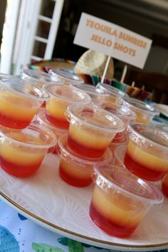 there are many cups with drinks in them on the table and one is filled with orange juice