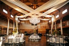 the inside of a building with tables and chairs set up for a formal function,