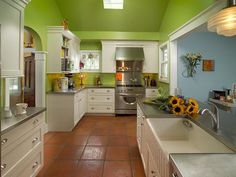 a kitchen with sunflowers in the center and white cabinets on the other side