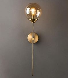 a wall light that is on the side of a wall with a glass ball hanging from it