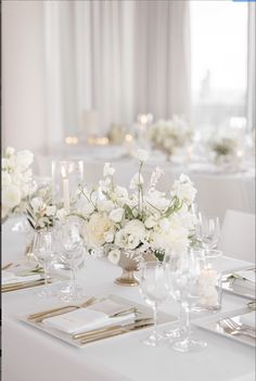 the tables are set with white linens and flowers