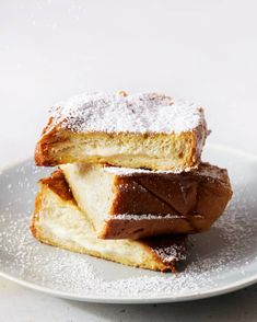 two pieces of cake sitting on top of a white plate covered in powdered sugar