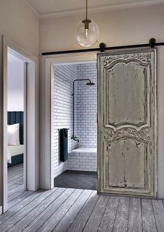 an open door leading to a bathroom with white brick walls and wood flooring in the background