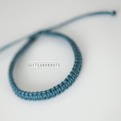 a close up of a blue string on a white surface with the words gifts and knots written across it