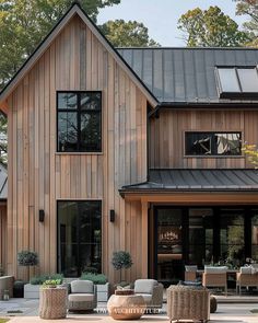 a house that is made out of wood and has lots of furniture on the patio