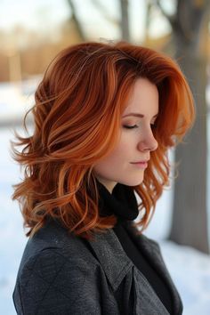 a woman with red hair standing in the snow