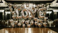 balloons are arranged in the shape of letters spelling love on a table at a party