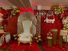 a room decorated with red and gold balloons, white chairs, and other holiday decorations