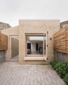 a brick house with an open patio and wooden fenced in area on the side